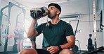 Gym, drinking water and man with fitness, training and hydration with workout or challenge. Person, guy or athlete with wellness or health with liquid, strong or endurance with nutrition and exercise