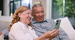 Home, senior couple and cellphone with video call, digital app and social network in a living room. Pensioner on a couch, elderly woman and old man with a smartphone, mobile contact or communication