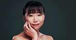 Korean, beauty and face of woman with skincare in studio with confidence and pride from dermatology. Happy, girl and smile for healthy glow on natural skin from facial or cosmetics in dark background