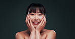 Korean, face and woman with beauty from skincare in studio with confidence or pride from dermatology. Happy, girl or smile for healthy glow on natural skin from facial or cosmetics in dark background