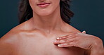 Body, hands and skincare of model, beauty or chest in studio isolated on a blue background. Closeup, touch and person in makeup cosmetics, spa treatment for dermatology or glow of healthy smooth skin