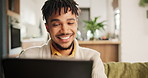 Tablet, video call and young man on sofa talking online in living room of modern apartment. Communication, speaking and male person on virtual conversation with digital technology at home or house.