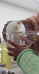 Hands, measuring milk and parent with kid in kitchen of home closeup for cooking or baking together. Family, learning and child development with people in apartment for baked food preparation