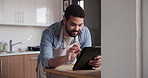 Happy man, tablet and apron in kitchen for cooking recipe, ingredients or online tutorial at home. Male person or chef with technology for virtual class, course or reading research on food at house