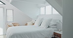 Empty bedroom, home and furniture for holiday, vacation and accommodation in hotel or apartment interior design. Bed, house and hospitality with white pillow, blanket and duvet for comfort or getaway