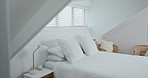 Empty bedroom, house and furniture for holiday, vacation and accommodation in hotel or apartment interior design. Bed, home and hospitality with white pillow, blanket and duvet for comfort or getaway