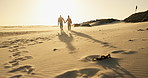 Couple, holding hands and walking on beach, sunset and bonding together on vacation at sea. Back, people and partnership or support on ocean adventure, love and travel on anniversary and romance