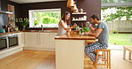 A young couple bonding and talking over coffee and telework in the kitchen