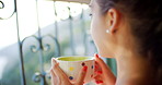 A content young woman drinking a cup of tea while enjoying the view