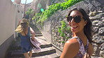 Two excited women climbing stairs to explore a city while on holiday together