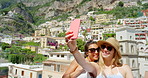 Two happy young women taking selfies together while on holiday in Italy