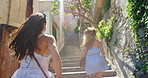 A happy young woman looking back while running up some steps with her friend