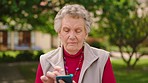 Phone, retirement and senior woman on social media in nature, garden or park enjoy an app. Happy elderly person smile while text contact or browsing web on cellphone, smartphone or mobile outdoors