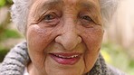 Face, happy and smile with a senior woman standing outside in the garden of her assisted living home. Closeup portrait of an elderly female pensioner with a positive, carefree and cheerful expression