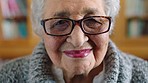 Happy senior woman, smile and wisdom with glasses against a blurred background in a library. Portrait of a elderly female face smiling in smart, knowledge and wise happiness with a positive attitude