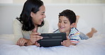 Tablet, happy and child with mother on bed watching video, movie or show on the internet. Smile, bonding and boy kid with young mom streaming film on digital technology in bedroom at family home.