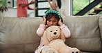 Fighting, parents and girl on a sofa with teddy bear for comfort from noise, shouting or toxic parents at home. Family, stress or kid in a living room with hands on ears, anxiety or fear of conflict