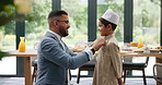 Father, dressing and muslim child in home, hug and happy family bonding together for Ramadan kareem. Islam, smile and dad embrace kid in hat to help button clothes for love, care and support on Eid