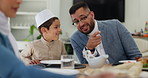 Family, dad and child at table for eid celebration, Muslim people at dinner together eating and talking. Islam, father and son at Iftar in dining room for holy festival, culture and Ramadan in home.