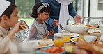 Muslim, family and children with food or lunch at dining table for eid, islamic celebration and hosting. Ramadan, culture and people eating at religious gathering with dinner, discussion or happiness