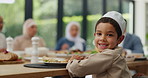 Kid, face or muslim family at table in home with lunch, plate or celebration in social gathering event. Group of people, happy boy eating or male child with dinner, meal or food with feast or smile