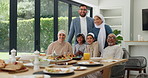 Muslim family, eid lunch and happy for celebration, islamic festival and food for religious holiday. People, portrait and bonding at table for special event, generations and traditional meal at home