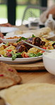 Table, healthy food or hands of family in a house with lunch, drinks or celebration in social gathering event. Group of people, eating or plate closeup with dinner, meal or brunch with salad or bowl 