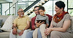 Tablet, education or development with family on sofa in living room of home together for visit or bonding. Father, son and grandparents with technology for social media, game or learning in apartment