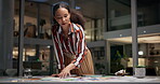 Fashion, designer and woman organising and pressing on paperwork or document in her studio. Fashion designer, creative studio and female organising her desk and creative designs in her office 