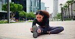 Fitness, running and woman stretching in the city, getting ready for exercise or workout for cardio. Exercise, training and warm up with confident young runner or athlete in urban town for sports