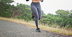 Woman, running and legs in exercise on mountain for marathon, training or outdoor workout in nature. Fast, runner and steps of shoes on ground in cardio, fitness and athlete on path in environment