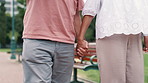 Couple, holding hands and love on walk in park, bonding and support or trust in commitment. People, closeup and loyalty or romance in relationship, partnership and care for marriage in outdoors