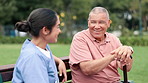 Happy, nature and nurse on bench with an old man in a park garden for wellness or conversation. Relax, talking or caregiver with smile or senior person for outdoor rehabilitation, love or nursing