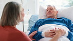 Senior couple, holding hands and support on bed in hospital, medical conversation and cancer diagnosis. Sick elderly man, woman and comfort for love, empathy and faith in healthcare rehabilitation