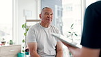 Senior, man and therapist in consultation with tablet for healthcare, advice or wellness at hospital. Mature male person talking to nurse or chiropractor in physiotherapy, nursing or rehabilitation