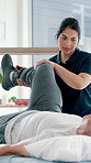 Physical therapy, leg pain and physiotherapist with senior man at clinic for injury recovery or treatment. Healthcare, consultation and medical worker helping elderly patient for rehabilitation.