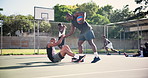 Sports, basketball and athlete helping friend for injury on outdoor court at training or game. Fitness, muscle accident and team of young African men lifting person practicing for match on pitch .