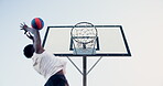 Basketball, black man and shooting in the net outside for athletic game and healthy lifestyle. Training, ball match and strong male person jumping to score for sports and exercising on a court