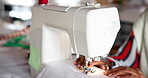 Hands, sewing machine and fabric in studio for manufacturing clothes, small business or production. Person, fingers and equipment in workshop for fashion tailor or ecommerce, pattern or creativity