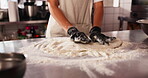 Baker, pressing or kneading of dough on table, chef or process of flour bread on kitchen counter. Person, gloves and working on cake recipe with skill, hospitality or culinary cooking in restaurant