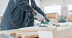 Engineering, woodwork and closeup of carpenter with grinder in a workshop manufacturing furniture. Career, industry and man industrial worker working and building timber with tool in warehouse.