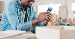 Phone, smile and closeup of man in workshop networking on social media, mobile app or internet. Happy, technology and African male carpenter typing online email or message on cellphone in warehouse.