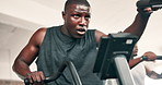 African man, cycling machine and gym for training, wellness or low angle with vision for challenge. Person, exercise bike and performance with thinking, workout and health for body at fitness club