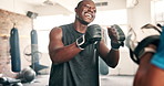 Black man, boxer and coach in gym for fitness, workout or training support in MMA, fight and practice target. People or personal trainer helping with boxing pads for impact, fist or sports challenge