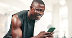 Man, phone and texting in gym with smile, reading or check notification for contact on mobile app. African person, smartphone and fitness with scroll for web blog on internet, social media and chat