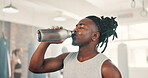 Black man, drinking water and training in gym for exercise break and health, boxing energy or fitness challenge. Sweat and thirsty sports person or boxer with bottle, liquid or nutrition for workout 