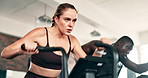 Fitness, cardio and woman on machine in gym for intense workout, training and exercise for healthy body. Sports, sweating and people on cycling equipment for performance, endurance and wellness