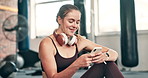 Typing, fitness and woman with phone in gym for social media, text message and online chat after workout. Sports, typing and person on smartphone rest or relax for training, exercise and wellness