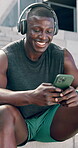 Black man, phone and fitness in city with social media, workout meme and listening to audio outdoor. Young runner, athlete or sports person laugh with headphones and mobile on training break and chat