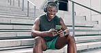 Fitness, headphones and black man with phone in city to relax on steps with audio, streaming and subscription. Workout, smile and runner on break listening to music, podcast or exercise app on stairs